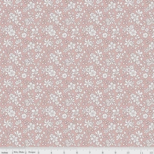 May include: A floral fabric with a repeating pattern of white flowers and leaves on a dusty rose background. The fabric is marked with inch measurements along the bottom edge, indicating a width of approximately 12 inches.