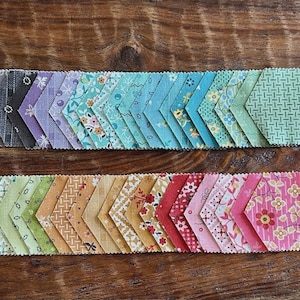 May include: A white ceramic mug with a black handle and the text "But First, Coffee" in a bold, black font. The mug is set against a blurred background, suggesting a cozy setting.