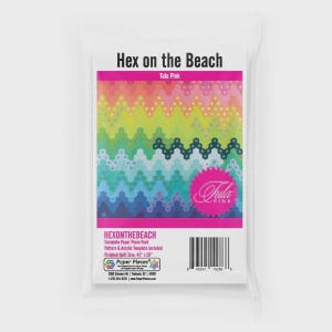 May include: A package labeled "Hex on the Beach" featuring a colorful quilt pattern. The design includes a vibrant gradient of pink, yellow, green, and blue zigzags. The package also includes the "Tula Pink" logo and the text "HEXONTHEBEACH".