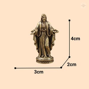 Puede incluir: Una estatua de bronce de Jes&uacute;s con los brazos extendidos, de pie sobre una base decorativa. La estatua mide 4 cm de alto, 3 cm de ancho y 2 cm de profundidad. La figura tiene pelo largo y barba, y lleva una t&uacute;nica.