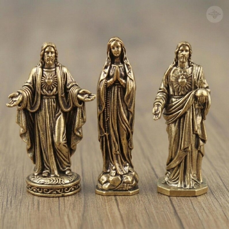 Puede incluir: Tres estatuas religiosas de bronce. La estatua de la izquierda representa una figura con los brazos extendidos, la estatua central muestra una figura con las manos juntas en oraci&oacute;n y la estatua de la derecha representa una figura sosteniendo un globo.