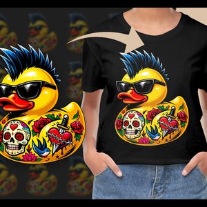 Könnte beinhalten: Schwarzes T-Shirt mit einem gelben Enten-Design. Die Ente hat einen blauen Irokesenschnitt, eine Sonnenbrille und Tätowierungen, darunter einen Totenkopf, Rosen und ein Herz mit einem Dolch. Das Design wiederholt sich im Hintergrund.