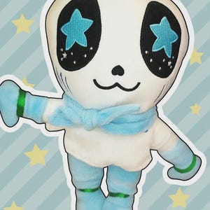 May include: A plush doll with a white head and body, blue accents, and star-shaped eyes. The doll has a blue scarf, gloves, and socks with green trim. The text "DOLL INCLUDED" is at the top.
