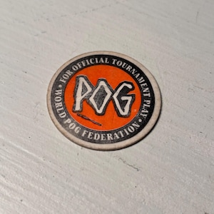 May include: A circular POG slammer with the text "POG" in white letters on an orange background. The text "WORLD POG FEDERATION" and "FOR OFFICIAL TOURNAMENT PLAY" are printed around the edge in black.