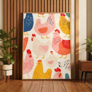 May include: A framed art print with a repeating pattern of colourful chickens in shades of pink, yellow, blue, and orange on a white backdrop. The artwork is displayed in a room with wooden flooring and a wooden wall.