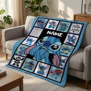 Op de afbeelding: Een blauwe fleece deken met een grote centrale afbeelding van het personage Stitch, omringd door een raster van kleinere panelen die Stitch in verschillende houdingen tonen. De tekst "NAME" en "OHANA MEANS FAMILY" staat op de deken gedrukt.