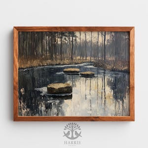 May include: Oil painting of a serene landscape featuring a dark, reflective body of water with three stepping stones. The artwork is framed in a wooden frame. The background shows a forest of bare trees under a muted sky. The painting is signed "Harris Prints".