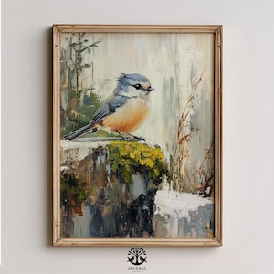 May include: A framed painting of a small bird with blue, gray, and orange plumage perched on a mossy rock. The artwork has a textured, impressionistic style with a neutral background and a gold-colored frame. The painting is signed "Harris Prints".