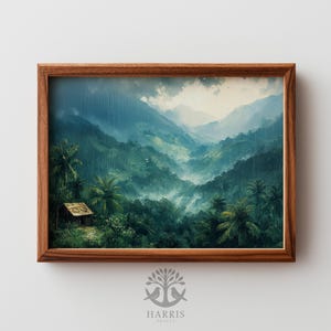 Puede incluir: Una impresión enmarcada de un paisaje tropical. La obra representa un valle exuberante y verde con montañas al fondo, bajo un cielo lluvioso. Una pequeña cabaña es visible entre las palmeras. El marco es de madera oscura.
