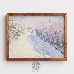 May include: A framed winter landscape painting. The artwork depicts a snow-covered path winding through a field, with lavender-colored bushes on the right and snow-laden branches on the left. The frame is made of wood.