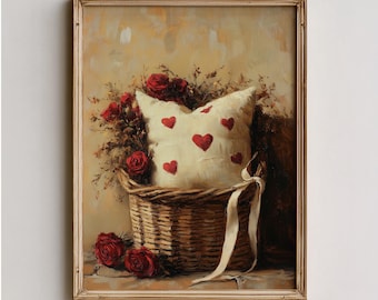 May include: A framed painting depicts a woven basket filled with a cream-colored pillow adorned with red hearts and surrounded by red roses. A white ribbon drapes from the basket. The artwork has a vintage aesthetic.