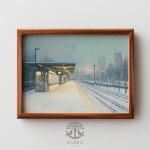 May include: A framed print of a snowy train station scene. The artwork depicts a platform with a shelter, tracks, and city buildings in the background. The image is encased in a brown wooden frame.