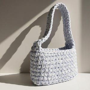 Könnte beinhalten: Ein Set aus drei Keramikbechern mit gesprenkelter, matter Oberfläche. Jeder Becher hat eine andere Farbe: hellblau, cremefarben und grau. Die Becher haben ein schlichtes, modernes Design und einen bequemen Griff.