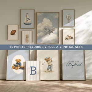 May include: A collection of wall art prints featuring vintage-style illustrations of a sailboat, a football, alphabet blocks, a biplane, a hot air balloon, a toy car, teddy bears, and the text 25 PRINTS INCLUDING 2 FULL A-Z INITIAL SETS.