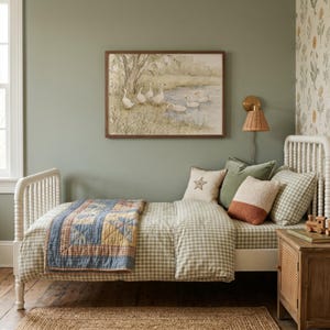 May include: A white spindle bed frame with green and white gingham bedding, a blue and yellow patchwork quilt, and several decorative pillows. Above the bed hangs a framed watercolor print of geese near a pond in a muted, natural color palette.