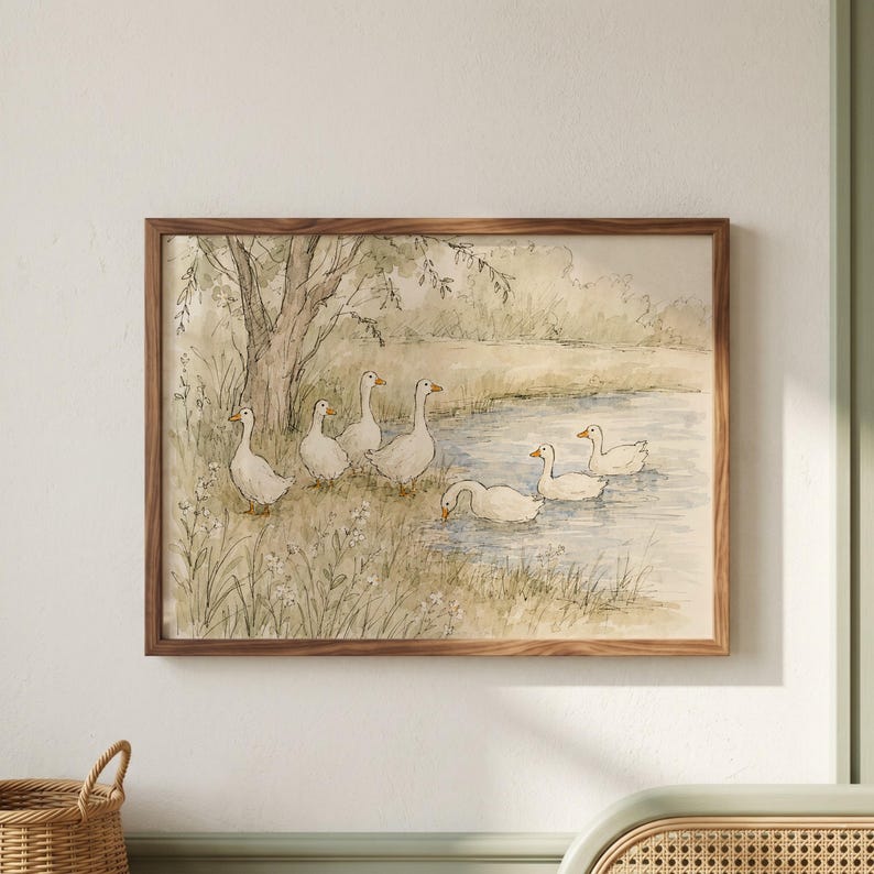 May include: A framed watercolor print depicting a group of white geese near a pond. The scene features a large tree on the left, grassy banks, and several geese standing on the shore or swimming in the water, rendered in soft, muted earth tones.