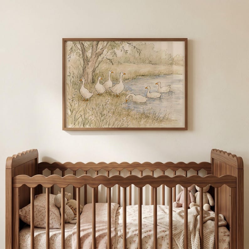 May include: A framed watercolor print featuring a group of white geese near a pond and a tree, displayed above a wooden crib with a scalloped top rail. The artwork uses soft, muted tones of green, brown, and blue to depict a natural landscape.
