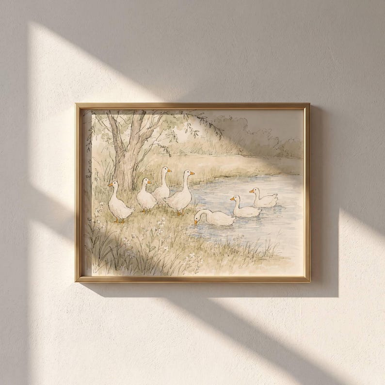 May include: A framed watercolor print featuring a group of white geese near a pond. Three geese stand on the grassy bank under a tree, while three others swim in the water. The artwork uses soft, muted earth tones and light blue water accents.