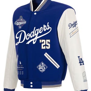 Pode incluir: Uma jaqueta de beisebol dos Dodgers azul e branca. A jaqueta apresenta o nome da equipe em escrita branca, o número '25' e vários patches, incluindo 'World Series Champions'. As mangas são brancas, e a gola e os punhos têm listras.