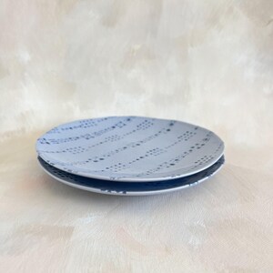 Puede incluir: Dos platos de cer&aacute;mica azul claro apilados. Los platos tienen un patr&oacute;n de puntos en un color azul m&aacute;s oscuro. Los platos son redondos y tienen un dise&ntilde;o simple y elegante.