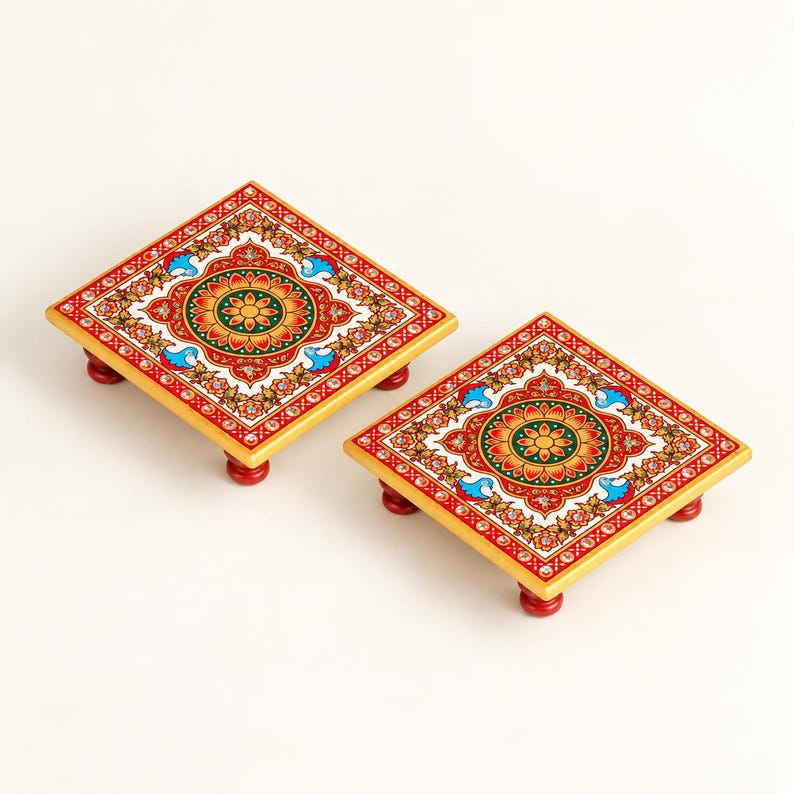 May include: Two square wooden platforms with four small red feet each. The top surfaces feature a vibrant, symmetrical floral pattern in shades of red, green, yellow, and blue, accented with small white dots and gold-coloured borders.
