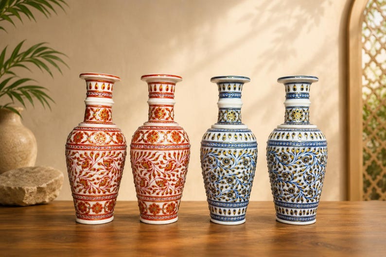 K&ouml;nnte beinhalten: Vier dekorative Vasen in einer Reihe. Zwei Vasen zeigen komplizierte rote und orangefarbene Blumenmuster auf wei&szlig;em Grund, w&auml;hrend die anderen beiden detaillierte blaue und gelbe Blumendesigns aufweisen. Jede Vase hat einen schmalen Hals.