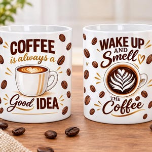 May include: Two white ceramic mugs featuring brown coffee bean patterns. The left mug displays a coffee cup illustration with the text "COFFEE is always a Good IDEA". The right mug shows a latte art illustration with the text "WAKE UP AND SMELL THE Coffee".