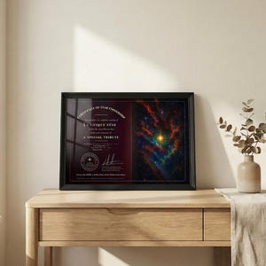 Può includere: Certificato incorniciato di proprietà stellare. Il certificato presenta un'immagine colorata di una nebulosa con una stella luminosa al centro. Il testo sul certificato recita "A Unique Star" e "A Special Tribute". La cornice è nera e il certificato è su un tavolo di legno.