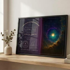 Può includere: Certificato incorniciato di proprietà di una stella con il testo "A Unique Star" e "A Special Tribute". L'opera d'arte presenta una vivace nebulosa con sfumature di blu, viola e oro. La cornice è nera e il certificato è esposto su una superficie di legno.