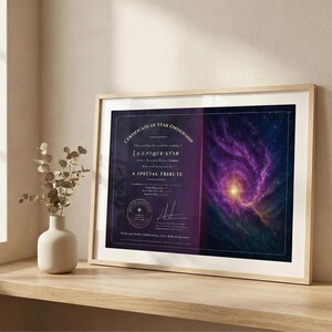 Può includere: Certificato incorniciato di proprietà stellare. Il certificato ha uno sfondo blu scuro con testo dorato e un'immagine colorata di nebulosa. Il certificato è in una cornice di legno chiaro ed è esposto su una mensola di legno.
