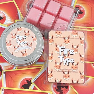 May include: A set of six pink wax melts in a clear plastic container. The wax melts are shaped like squares and are arranged in a grid pattern. The container is labeled with the text "Fire Type" and a website address. The wax melts are surrounded by Pokemon trading cards with a fire theme.