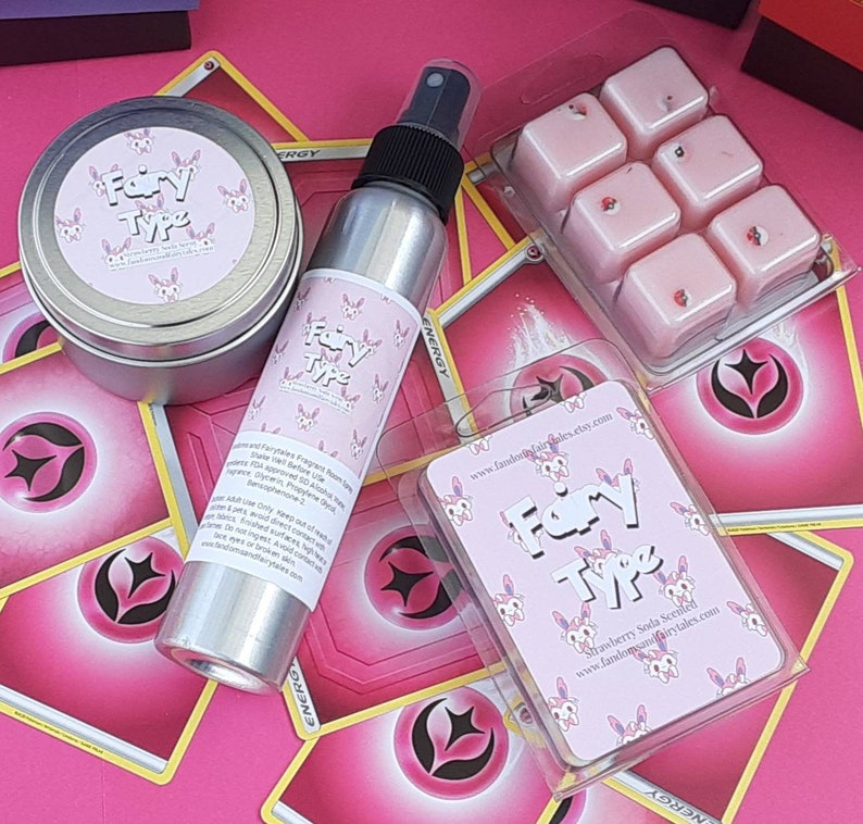 May include: A set of pink and white fairy-themed wax melts, a pink and white fairy-themed room spray, and a pink and white fairy-themed card with the text "Fairy Type" and "Strawberry Soda Scented".