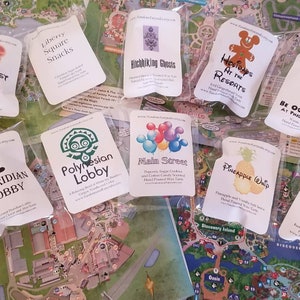 May include: Assortment of colorful wax melt labels featuring various Disney park locations and attractions. The labels include Liberty Square Snacks, Hitchhiking Ghosts, Holidays at the Resorts, Polynesian Lobby, Main Street, Pineapple Whip, and a map of the park.