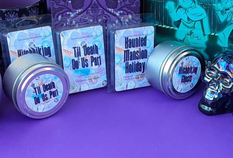 Puede incluir: Cuatro latas de velas plateadas con etiquetas coloridas. Las etiquetas tienen el texto "Hitchhiking Ghosts", "Til Death Do Us Part", "Haunted Mansion Holiday" y "Til Death Do Us Part".