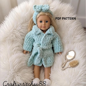 May include: A doll wearing a light blue textured bathrobe and a matching headband with a bow. The doll has blonde hair and blue eyes. Next to the doll are a silver hand mirror and a small hairbrush. The text PDF PATTERN is visible.