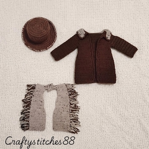May include: A crocheted set consisting of a brown hat, a brown long-sleeved jacket with a light grey collar, and light grey chaps with brown fringe detailing. The text "Craftystitches88" is printed in black at the bottom of the image.
