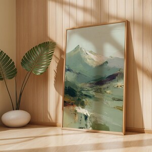 a large framed painting of a mountain landscape, placed on a wooden wall next to a potted plant.