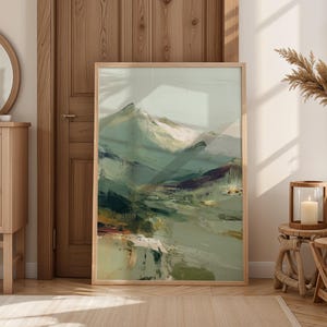 a large, abstract painting of a mountainous landscape, displayed in a wooden frame and placed in a room with a mirror, a wooden cabinet, and some decorative elements.