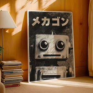 a large black and white poster of a robot with the text "おいしい" (which means "perfect" or "perfectly") written on it. The poster is displayed in a living room setting, with a lamp, a stack of books, and a window in the background.
