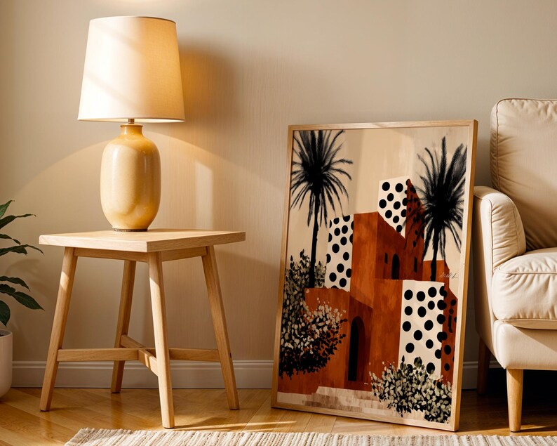 a living room with a wooden side table, a lamp, and a framed artwork depicting a tropical scene with palm trees and a building with a distinctive orange and white color scheme.