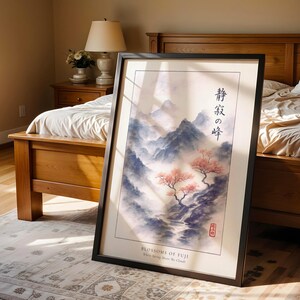 A framed poster of a serene landscape with mountains and cherry blossoms is displayed in a bedroom, with a wooden bed and a lamp in the background.