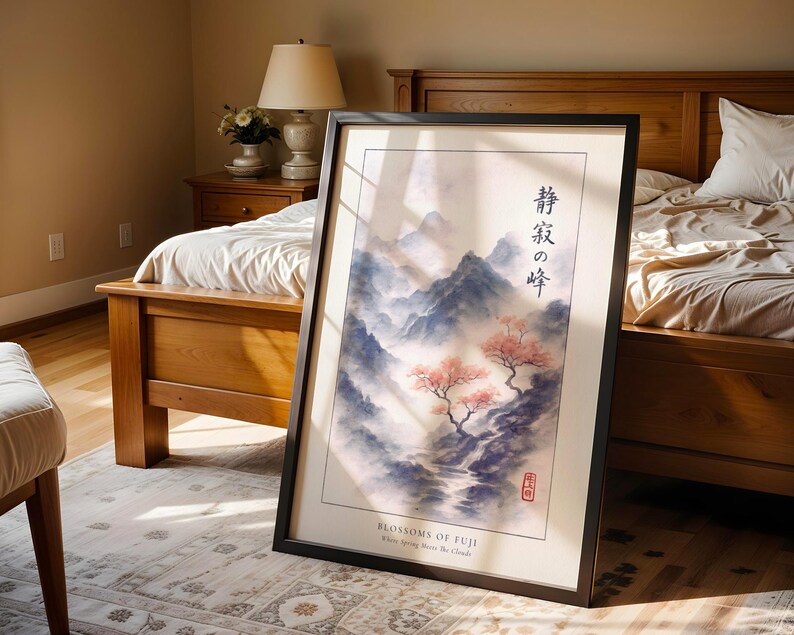 A framed poster of a serene landscape with mountains and cherry blossoms is displayed in a bedroom, with a wooden bed and a lamp in the background.