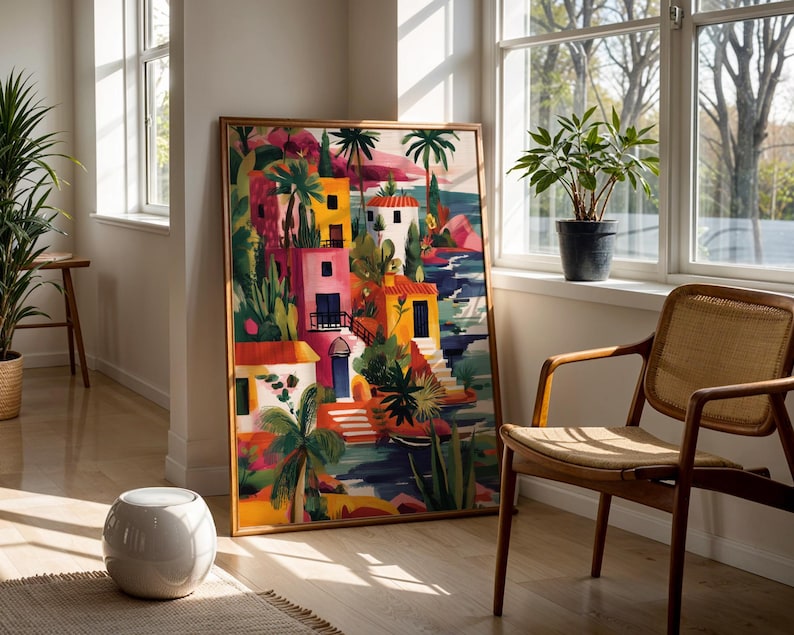 a vibrant, colorful painting of a tropical landscape, with palm trees, buildings, and water, displayed in a room with a large window and a woven chair.