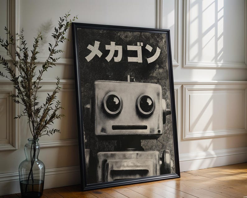 A framed black and white photograph of a robot with large eyes and a textured face, placed on a wooden floor next to a vase with greenery.