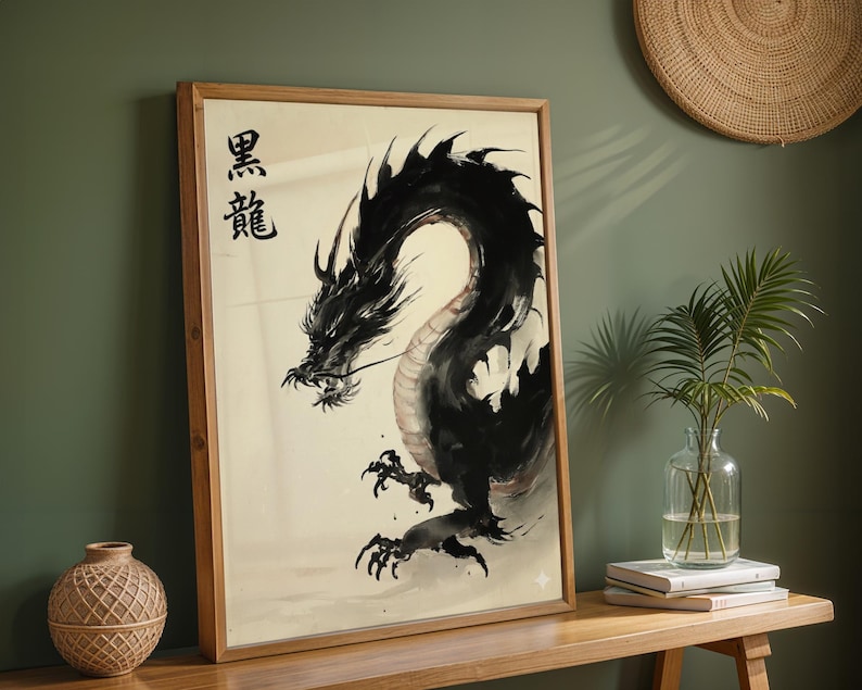 a framed artwork of a black dragon with a Chinese character above it, placed on a wooden shelf next to a vase with a plant and some books.
