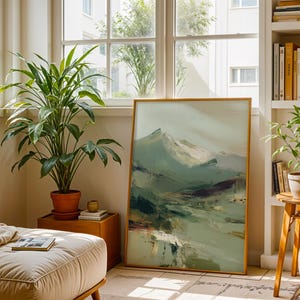 a cozy living room with a large painting of a mountain landscape hanging on the wall, a potted plant on a wooden table, and a bookshelf filled with books.