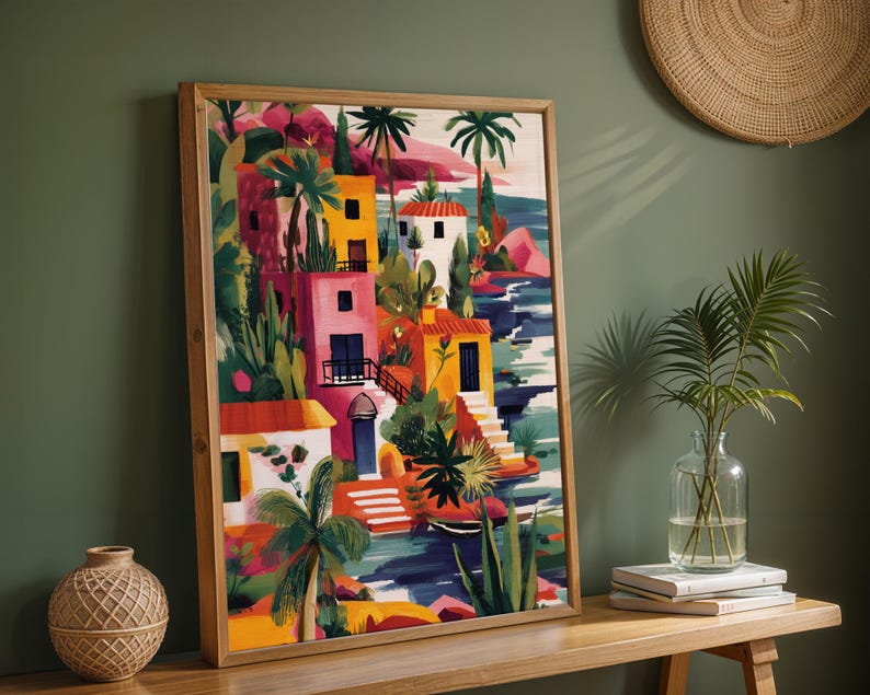 a vibrant, colorful painting of a tropical village, with buildings, palm trees, and other lush vegetation. The painting is framed and displayed on a wooden shelf, accompanied by a woven basket and a vase with a plant.