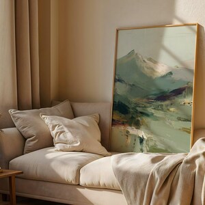 a cozy living room with a beige sofa, a large framed landscape painting on the wall, and a window with curtains.