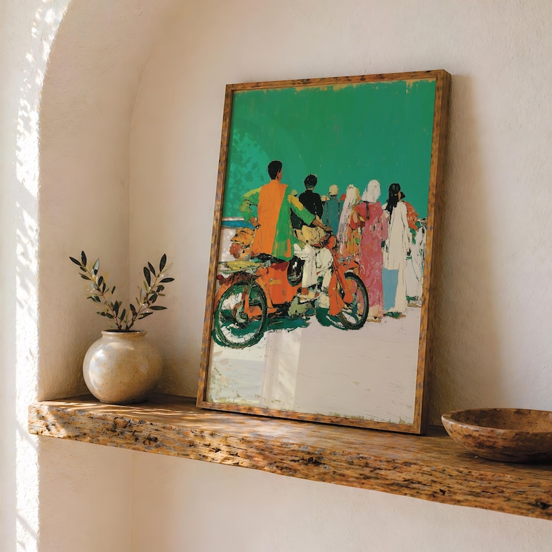 a framed painting of a group of people on a motorcycle, displayed on a wooden shelf.