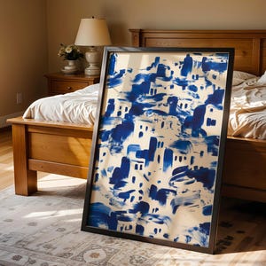 a large blue and white abstract painting displayed on a wooden bed frame in a bedroom setting.